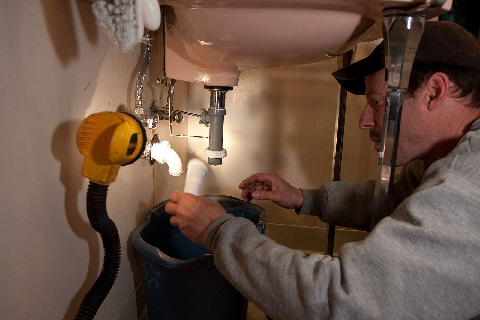 Plumber at work repairing pipes during an emergency call