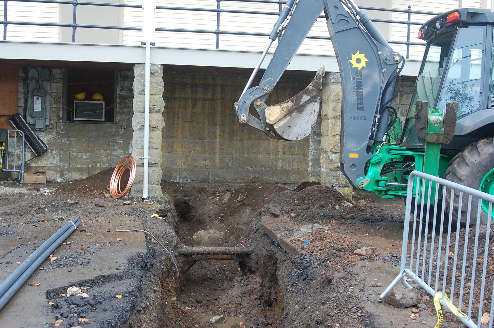 Crew repairing a damaged underground water line in an excavated trench